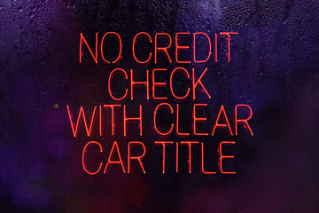 Fototapeta na wymiar Neon Sign No Credit Check with Clear Car Title in rainy window