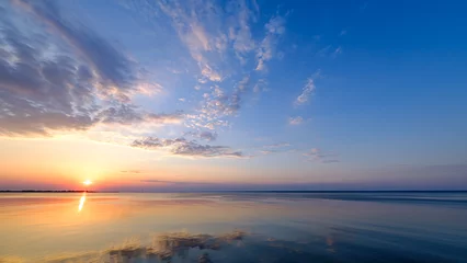 Schöner, farbenfroher Sonnenuntergang, Sonnenaufgang über einem breiten Fluss. Dämmerungsstrahlen und -wolken reflektierten sich im ruhigen Wasser.