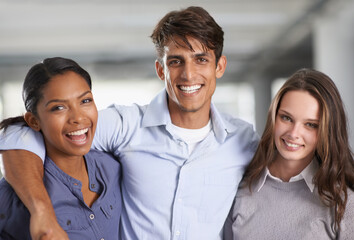 We have a fantastic work relationship. A group of businesspeople embracing each other in the office.