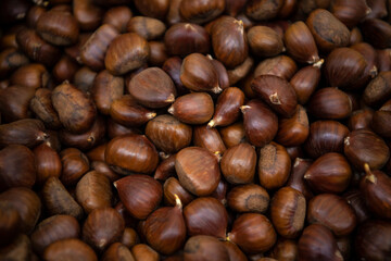 Pile of chestnuts at street market, freshly harvested. Natural background.