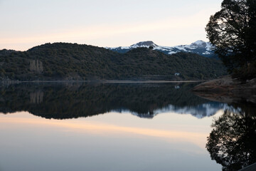 Magical view of the Andes mountains, forest and lake at sunset. Beautiful symmetrical reflection in the water.