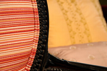 Classic furniture detail, selective focus. Close-up of striped fabric sofa with part of the wooden...
