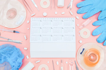 Surgeon's kit for surgery with an annual calendar 2022 and a colostomy bag on a soft pink...