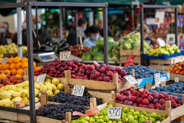 Fototapeta na wymiar Open air street market (pijaca) with freshly harvested fruit in Belgrade, Serbia. Colorful food, healthy lifestyle. Plums, figs, grapes, pears, peaches and oranges.