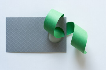 green paper ribbon and silver paper tag