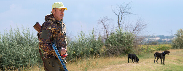 Hunter man in camouflage with a gun during the hunt in search of wild birds or game. Autumn hunting...
