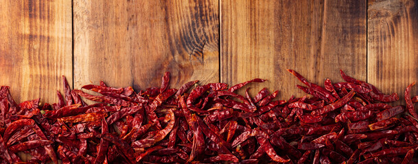 Chile de Arbol on wooden background. This potent Mexican chili can be used fresh, powdered or dried in a variety of Mexican dishes. panoramic top view