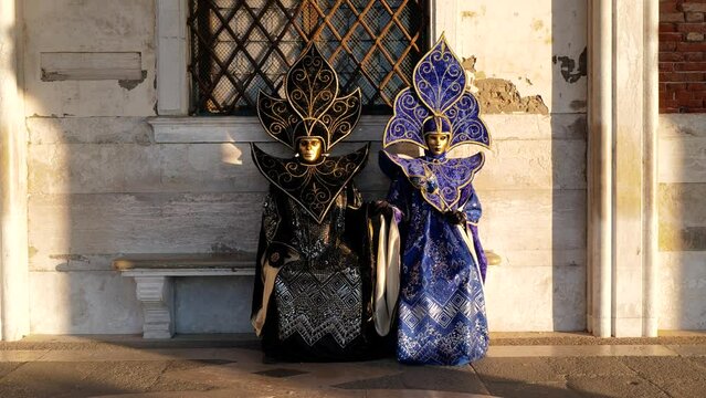 Venice, Italy - February 2022 - carnival masks are photographed with tourists in San Marco square
