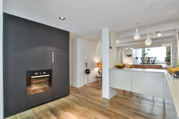 Interior of a compact white kitchen with black elements and white furniture
