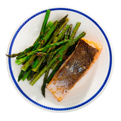 Homemade fried salmon steak with garnish of green asparagus. Isolated over white background