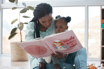 I swear my daughter is a better story teller than me. Shot of a woman reading a book to her daughter while sitting at home.