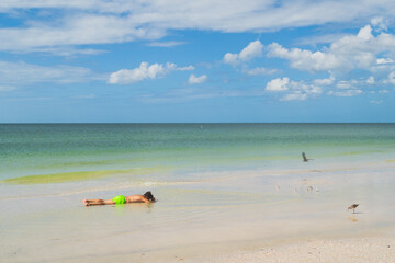 Fototapeta na wymiar Kids lying face down in water on beach