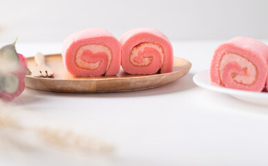 Pink strawberry roll cake or swiss roll with whipped cream and strawberry flavor on white background