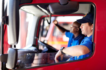 Waiting on the next call. Shot of firemen sitting in a truck.