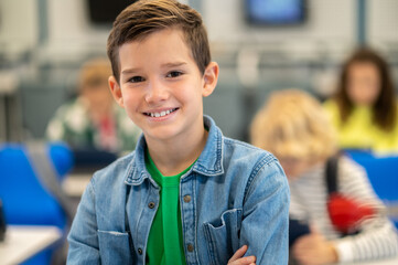 Boy smiling confidently at camera in class