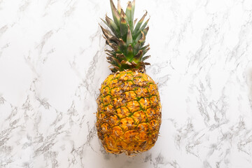 Ripe pineapple fruit on marble background