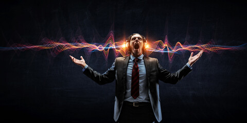 Young businessman with headphones . Mixed media