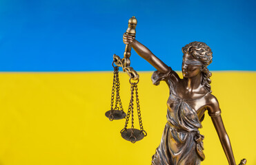 Lady Justice holding the scales on flag of Ukraine.