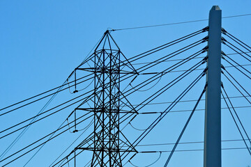 A mashup wire abstract.  Power line wires and suspension cables for bridge merge to form abstract...
