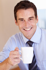 Enjoying his morning coffee. Smiling young businessman enjoying his coffee break.