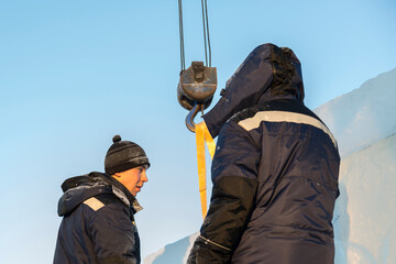 Portrait of a fitter in a blue jacket at the hook