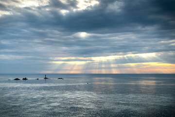Shafts of sunlight shining through clouds at sunset,Land's End,Cornwall,England,UK.