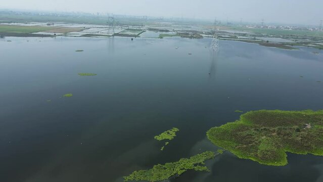 Aerial panning drone shot of agricultural lands covered in water due to floods in India.
