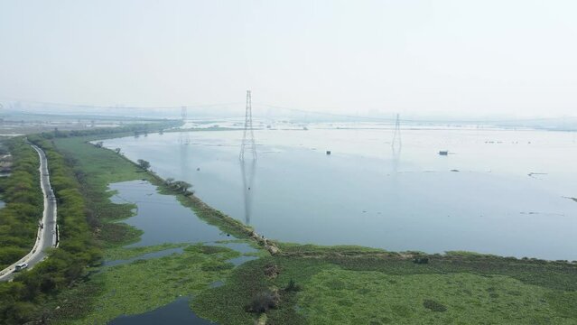 Aerial panning drone shot of agricultural lands covered in water due to floods in India.