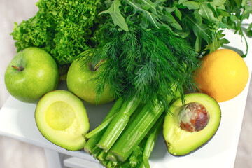 Vegetables and fruits closeup. The concept of healthy eating. Avocado, apples, celery, herbs, pineapple. Detox program. High quality photo