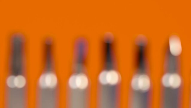 Close up view of tips of different screw driver tool bits on orange background.Defocused to focus zoom.