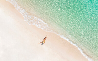 Aerial view of Beach vacation. Hot beautiful woman in sunhat lying on the beach -Summer concept