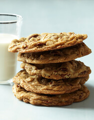 Stacking Chocolate Nut Cookies with Milk on Blue Table