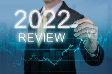 businessman writes 2022 review words. businessman writes 2022 results on virtual screen. economic...