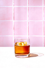 Whiskey or bourbon in a rocks glass with a big ice cube, shot with hard light and harsh shadows,...