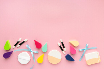 Obraz na płótnie Canvas Various makeup sponges and eyeshadow applicators on pink background, copyspace