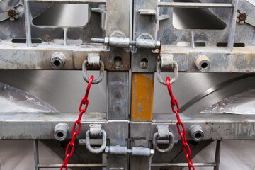 Red chains with hooks hold containers with blades for windmills.
