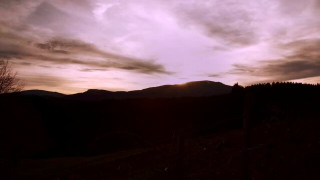 Heavenly golden sunset timelapse over a natural mountain backdrop.