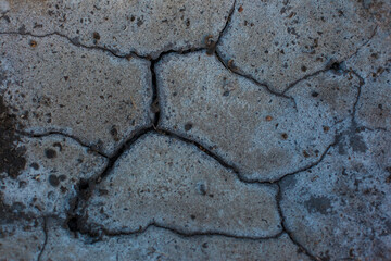 Texture of the dried earth. Dark gray background with cracks and hollows. Drought and lack of...