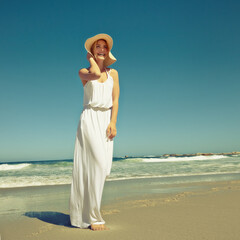 Fototapeta na wymiar Seaside styling. Shot of a beautiful young woman enjoying a day at the beach.