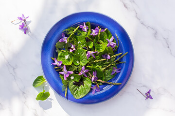 Fototapeta na wymiar Delicious lettuce and wildflower salad in a bowl