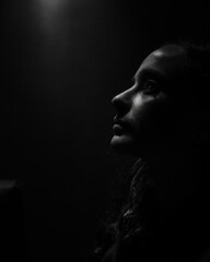 Portrait of girl in black and white, with shadow and illumination to the face.