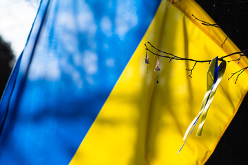 Ribbon on a branch of a tree with colors of Ukraine during a peaceful demonstration against war,...