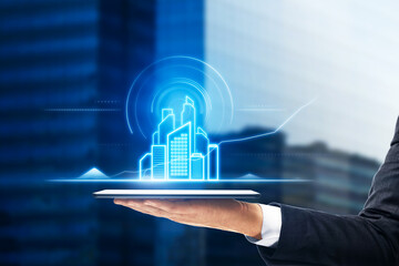 Close up of businessman hand holding tablet device with abstract smart city hologram on blurry background. Technology, innovation and communication concept. Double exposure.