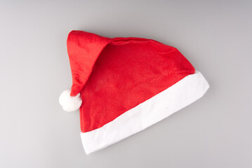 Red and white Santa Claus hat on a gray background.