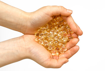 Vitamin capsules in the palms of a person on a white background. Dietary supplements: fish oil, omega-3, omega-6, omega-9, vitamin A, E, vitamin D, vitamin D3, evening primrose oil, borage.