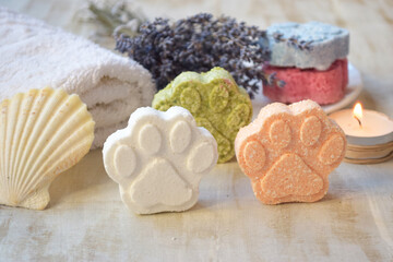 Paw shaped bath bombs for shower on the table, lavender, seashell and candle  - obrazy, fototapety, plakaty