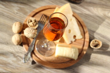 still life with glass of wine cheese walnut and fork on a table