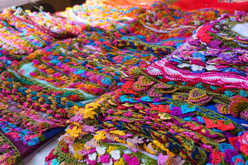 Stack of colorful crochet lace products in woman producer outdoor bazaar in Odemis, Izmir. Many or lots of different beautiful modern style needlework or handmade crochet laces.	