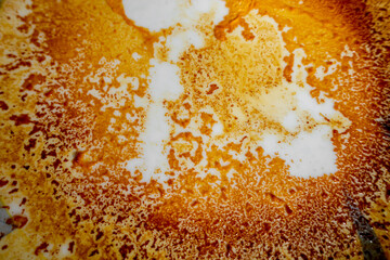 Abstract yellow-orange burning cream texture in white background. Milk burning pots orange-yellow texture. Abstract rustic texture.