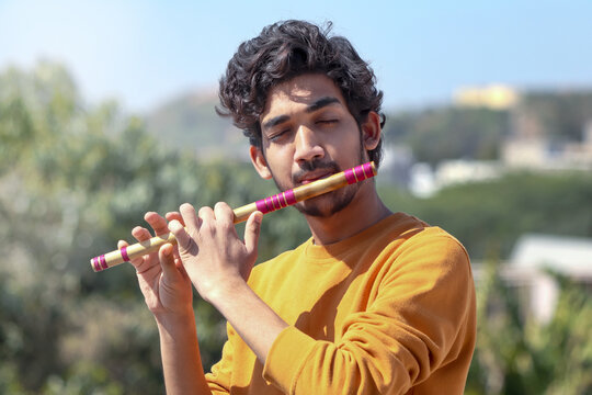 Indian boy playing bansuri Indian Bamboo Flute.